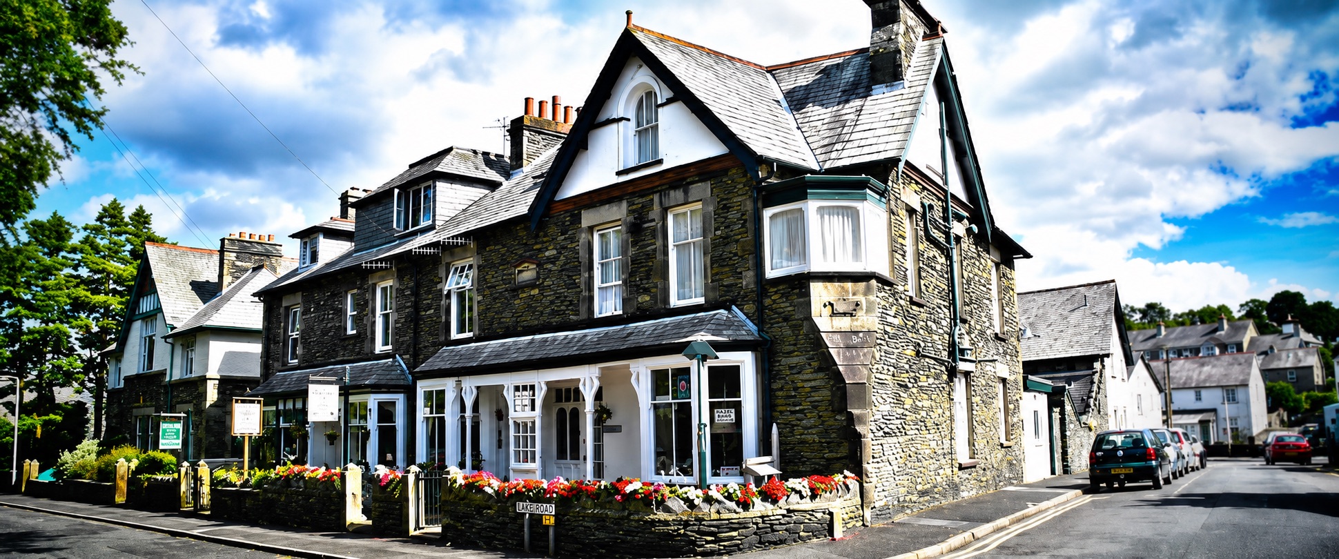 The stone-built Victorian frontage of Lynwood Guest House on Broad Street, Windermere, with flower boxes in bloom