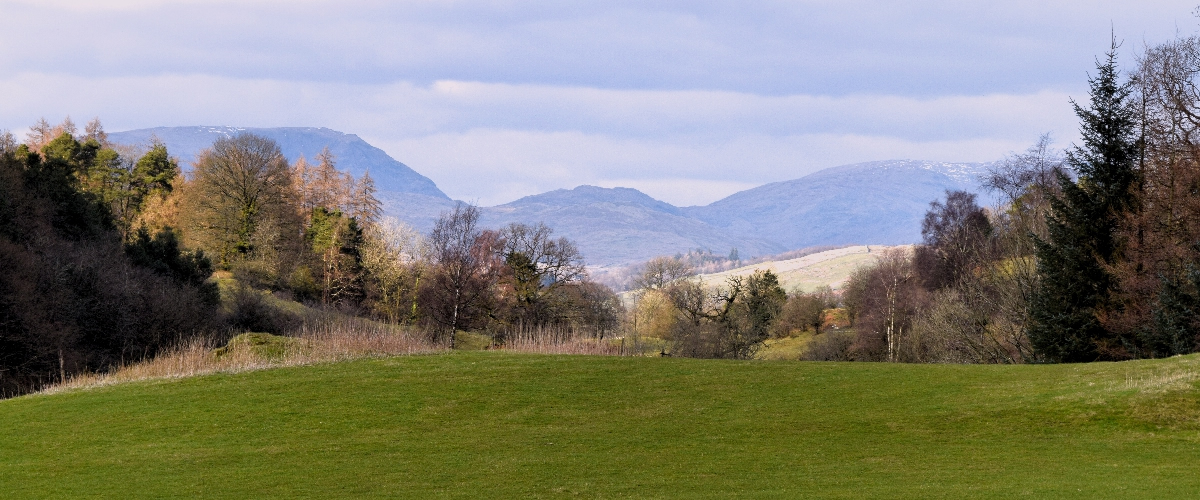 Rolling green fells and distant mountains of the Lake District